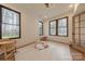 Bright bonus room featuring dark trim windows, wood floors, and peaceful wooded views at 13625 Buster Rd, Stanfield, NC 28163