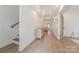 Bright hallway featuring wood floors, a staircase, and an open view to the living room at 13625 Buster Rd, Stanfield, NC 28163