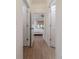 Hallway leading to a bedroom with a fan, white bedding and furniture, and a window with privacy shades at 13625 Buster Rd, Stanfield, NC 28163