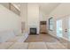 A living room with high ceilings, wood floors, a fireplace, a sectional, and many windows at 13625 Buster Rd, Stanfield, NC 28163