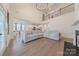 A living room with high ceilings, wood floors, a fireplace, a sectional, dining room, and many windows at 13625 Buster Rd, Stanfield, NC 28163