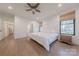 A main bedroom with a king bed, wood floors, many windows and entry to the main bathroom at 13625 Buster Rd, Stanfield, NC 28163