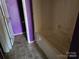 Bathroom with a purple accent wall and stained tub at 1421 Braveheart Ln, Charlotte, NC 28216