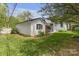 The backyard has a lush green lawn, a white outbuilding, and trees at 1519 The Plz, Charlotte, NC 28205