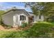 The backyard has a lush green lawn, a white outbuilding, and trees at 1519 The Plz, Charlotte, NC 28205