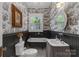 Charming bathroom with unique wallpaper, a clawfoot tub, and a pedestal sink at 1519 The Plz, Charlotte, NC 28205