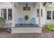 A charming front porch with blue chairs and a table at 1519 The Plz, Charlotte, NC 28205