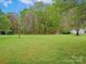 Large, grassy backyard with mature trees, storage shed, and plenty of open space at 1520 Venture Oaks Ln, Monroe, NC 28110