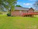 Spacious backyard featuring a red brick home with a deck and plenty of green space at 1520 Venture Oaks Ln, Monroe, NC 28110