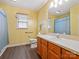 Bathroom with yellow walls, a wooden vanity, and a shower with blue curtains at 1520 Venture Oaks Ln, Monroe, NC 28110