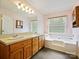 Bathroom with double sink vanity, large mirror, pink walls, and separate tub at 1520 Venture Oaks Ln, Monroe, NC 28110
