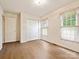 Bright bedroom featuring hardwood floors, a double window, and a double-door closet at 1520 Venture Oaks Ln, Monroe, NC 28110