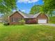 Charming brick home with a well-manicured lawn and attached two-car garage on a sunny day at 1520 Venture Oaks Ln, Monroe, NC 28110