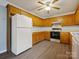 Traditional-style kitchen featuring wooden cabinets, white appliances, and modern flooring at 1520 Venture Oaks Ln, Monroe, NC 28110