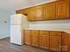 Bright kitchen showcasing wooden cabinetry, a white refrigerator, and updated flooring at 1520 Venture Oaks Ln, Monroe, NC 28110