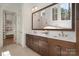 Bathroom with dual vanity, dark wood cabinets, and a large mirror reflecting the standalone tub and shower at 157 Silver Falls Dr, Troutman, NC 28166