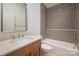 Bathroom featuring hexagon tile shower with tub, a toilet and light wood cabinets at 157 Silver Falls Dr, Troutman, NC 28166