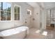 Relaxing bathroom with a standalone tub, large windows, and a glass-enclosed shower at 157 Silver Falls Dr, Troutman, NC 28166