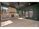 Inviting covered patio featuring a stone fireplace, concrete flooring, and elegant French doors for seamless indoor-outdoor living at 157 Silver Falls Dr, Troutman, NC 28166