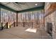 Spacious covered patio with a stone fireplace and forest views, ideal for outdoor entertaining and relaxation at 157 Silver Falls Dr, Troutman, NC 28166