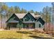 Stunning two-story home featuring green siding, a stone foundation, and beautifully landscaped front yard at 157 Silver Falls Dr, Troutman, NC 28166