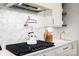 Close-up of the stove and counters. Stunning kitchen with pot filler and sleek appliances at 157 Silver Falls Dr, Troutman, NC 28166