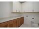 Laundry Room with white cabinets, stone countertops, and brown wooden lower cabinets at 157 Silver Falls Dr, Troutman, NC 28166