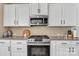 A kitchen featuring stainless steel appliances, granite countertops, and white cabinets provides a sleek culinary space at 1857 Felts Pkwy, Fort Mill, SC 29715