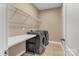 Functional laundry room with washer, dryer, folding table, and wire shelving for organized storage at 1857 Felts Pkwy, Fort Mill, SC 29715