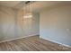 Open-concept dining room featuring wood floors and an elegant chandelier, perfect for Gathering gatherings at 190 Glastonbury Dr, Mooresville, NC 28115