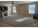 Bright living room with neutral-toned walls, a fireplace with decorative mantle, and large windows for natural light at 190 Glastonbury Dr, Mooresville, NC 28115