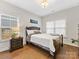 Bright bedroom with hardwood floors, nightstand, and comfortable decor at 2011 Trailwood Dr, Matthews, NC 28104