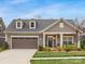 Charming home featuring a two-car garage, dormer windows and a welcoming front porch, perfect for suburban living at 2011 Trailwood Dr, Matthews, NC 28104