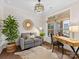 Bright home office with large window, wood desk, gray loveseat, decorative mirror and hardwood floors at 2011 Trailwood Dr, Matthews, NC 28104