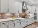 Close up of a stylish kitchen boasting white cabinets, a marble countertop, and stainless steel appliances at 2011 Trailwood Dr, Matthews, NC 28104