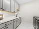 Clean and modern laundry room with ample counter space and storage cabinets at 2011 Trailwood Dr, Matthews, NC 28104