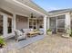 This lovely covered patio features comfortable outdoor seating, including sofas and chairs, and an attractive stone patio at 2011 Trailwood Dr, Matthews, NC 28104