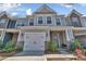 Attractive two-story townhome with a one-car garage, gray and brick facade, and landscaped front yard at 2149 Bexar Trl, Matthews, NC 28105