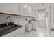 Well-equipped laundry room with modern appliances, granite countertop sink, lots of cabinets, and tile flooring at 261 Supernova Dr, York, SC 29745