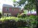 Brick home featuring a garden with vibrant flowers, a stone wall, and a basketball hoop at 2815 Glendale Rd, Charlotte, NC 28209