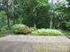 Paver patio with lush, mature landscaping creating a private outdoor space at 2815 Glendale Rd, Charlotte, NC 28209