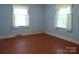 Light-filled bedroom featuring hardwood floors, two windows, and classic trim at 2815 Glendale Rd, Charlotte, NC 28209