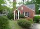 Charming brick home featuring a front entrance with white columns and lush landscaping at 2815 Glendale Rd, Charlotte, NC 28209