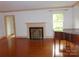 Spacious living room featuring hardwood floors, a fireplace, and natural light from a window at 2815 Glendale Rd, Charlotte, NC 28209