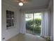 Bright sunroom with white-painted brick, large windows, and a view of the lush greenery at 2815 Glendale Rd, Charlotte, NC 28209
