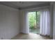 Sunroom with sliding glass doors leading to outdoor foliage, light carpet, and white paneled walls at 2815 Glendale Rd, Charlotte, NC 28209