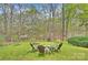 Enjoy the fire pit and lounge in the backyard chairs surrounded by lush greenery and trees at 2819 Blythe Rd, Waxhaw, NC 28173