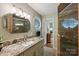 Updated bathroom features granite countertops, hexagon mirror and glass enclosed shower at 2819 Blythe Rd, Waxhaw, NC 28173