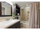 Bathroom with a dark vanity and shower/tub combination with tile surround and decorative shower curtain at 2819 Blythe Rd, Waxhaw, NC 28173
