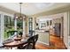 Cozy dining area with large windows, stylish light fixture, and view of the modern kitchen with stainless steel appliances at 2819 Blythe Rd, Waxhaw, NC 28173